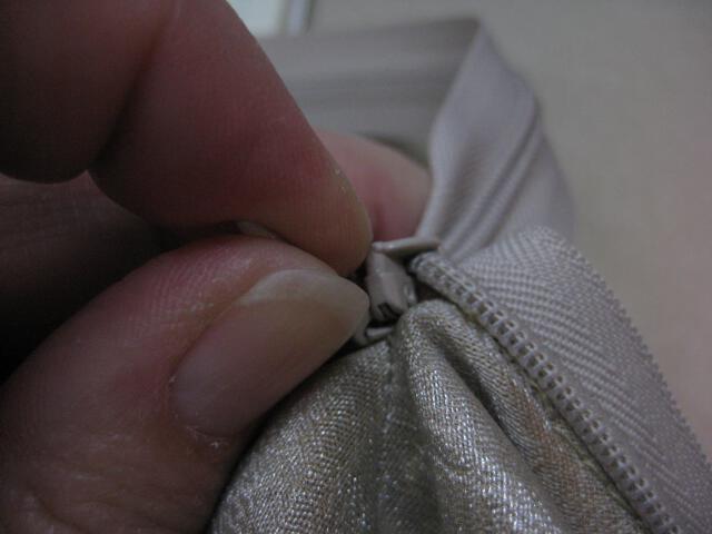 Invisible zipper tab comes through hole